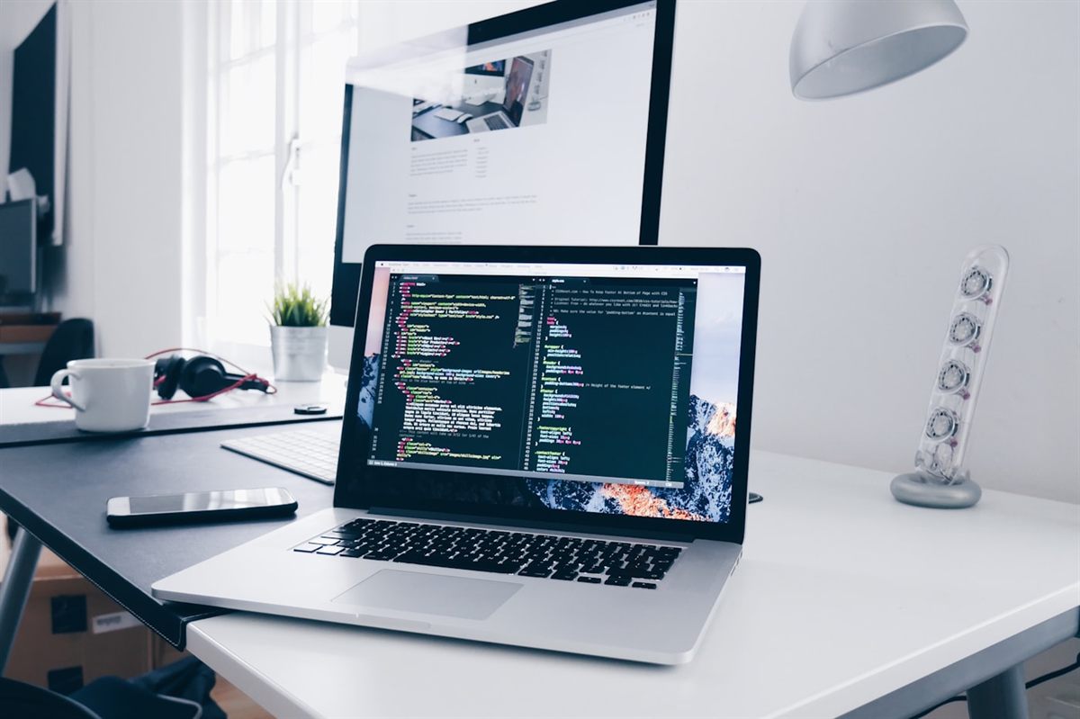 A developer's workstation with a code editor open on a laptop